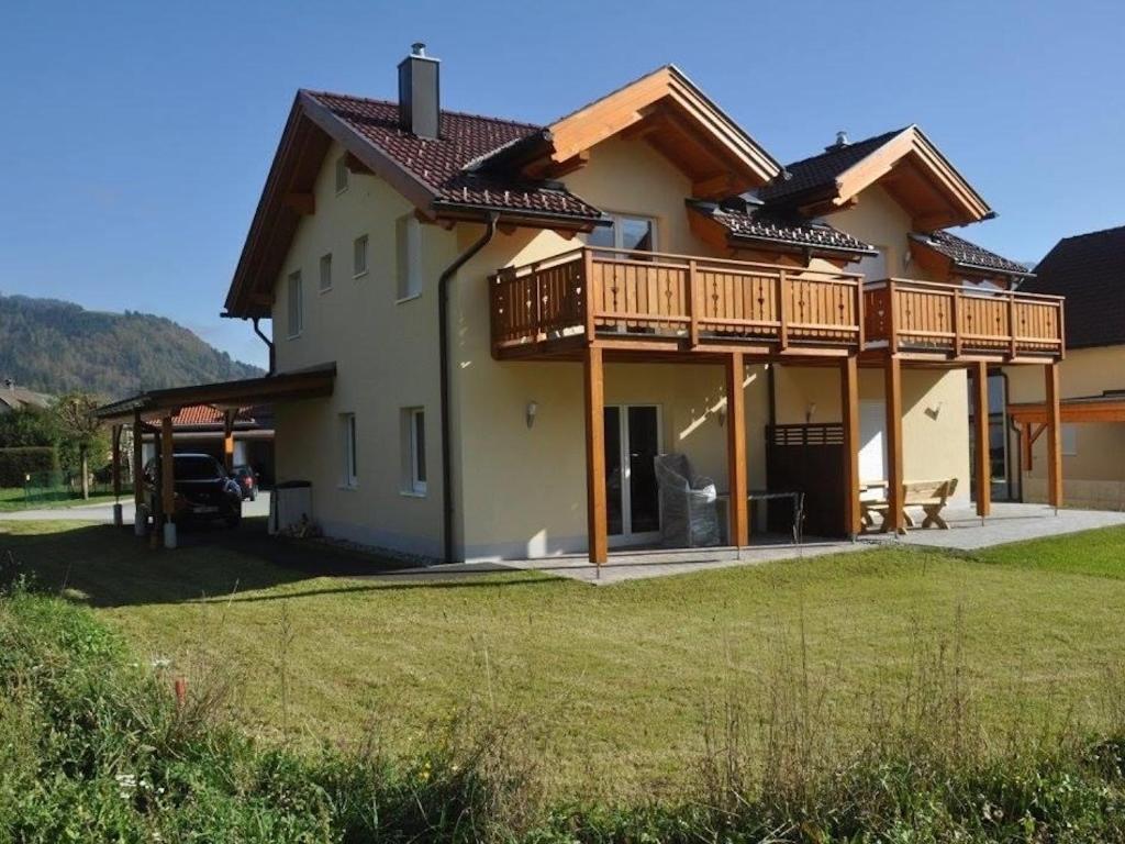 a large house with wooden balconies and a yard at Villa Sonnenblick in Kötschach