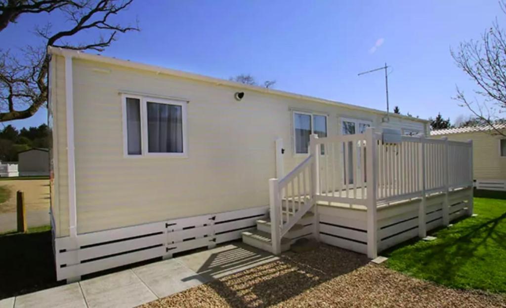 a mobile home with a white fence and stairs at 6. Supreme OD 2 Caravan with Decking in Ringwood