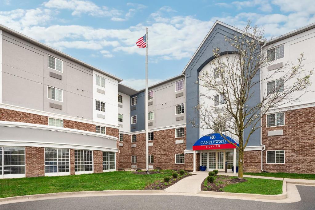 an exterior view of a building with an american flag at Candlewood Suites Indianapolis Northeast by IHG in Castleton