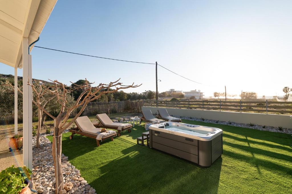 a backyard with a hot tub on the grass at GARDEN HOUSE, Kalamaki in Tympáki