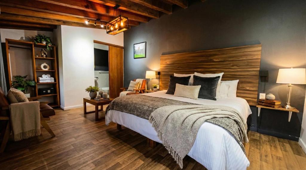 a bedroom with a large bed with a wooden headboard at Orgánico Hotel Boutique VALLE DE BRAVO in Valle de Bravo