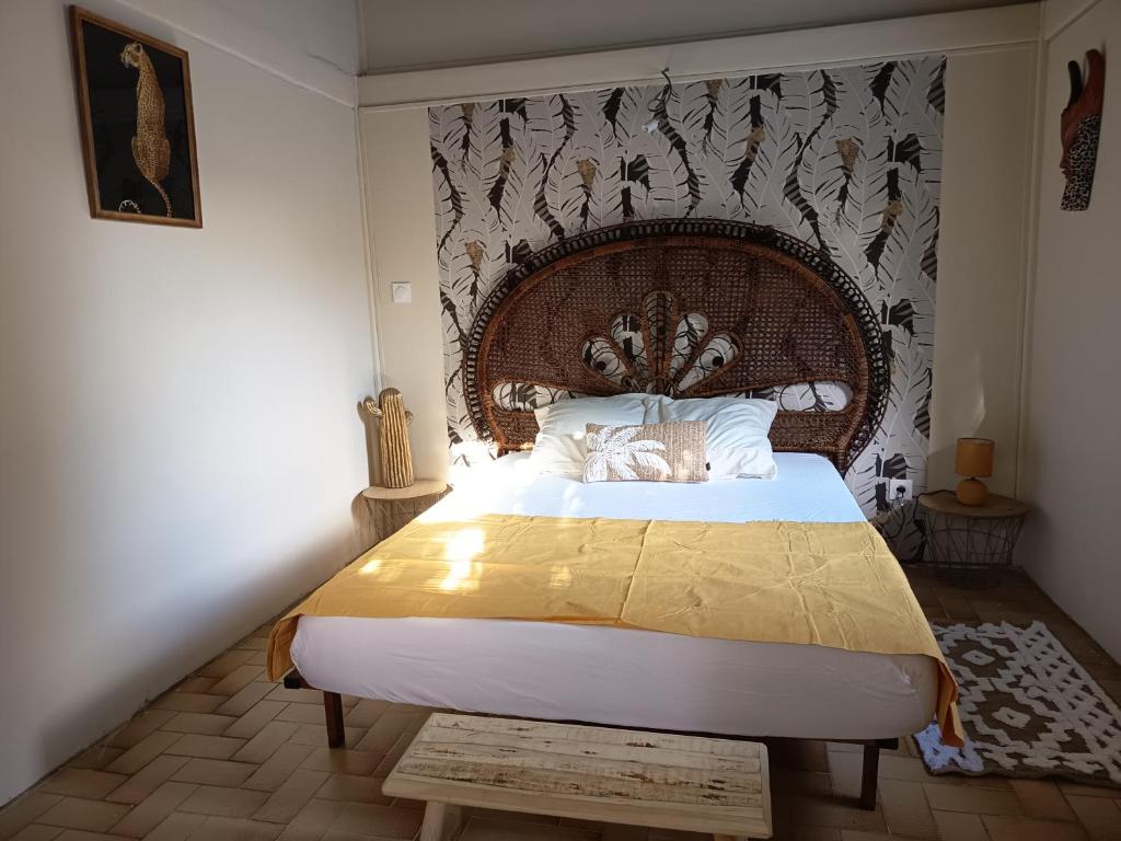 a bedroom with a large bed with a large headboard at Ma chambre Javanaise in Port-Louis