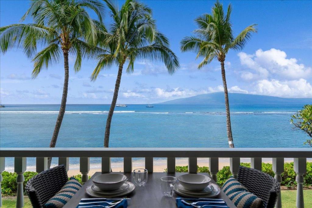 a table on a balcony with a view of the ocean at Lahaina203 in Lahaina