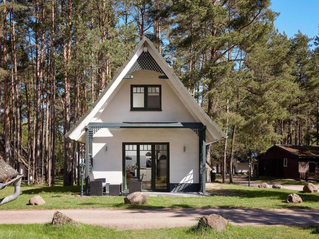 a small white house with a pointed roof at Ferienhäuser im Naturresort Drewitz in Drewitz