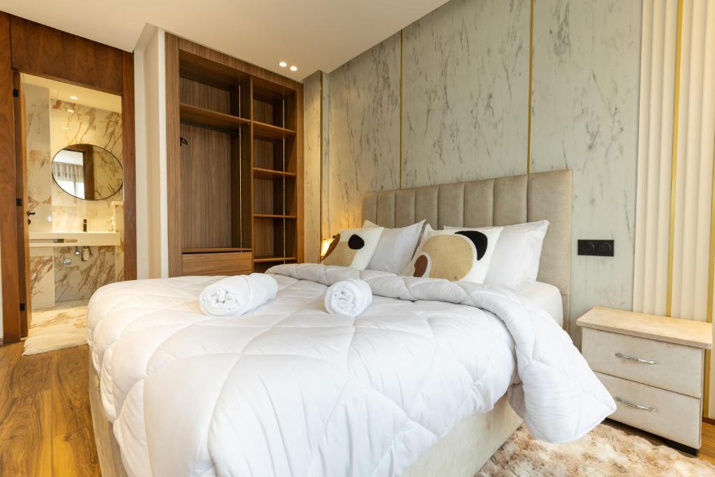 a bedroom with a large white bed with white pillows at Elite Home in Maarif