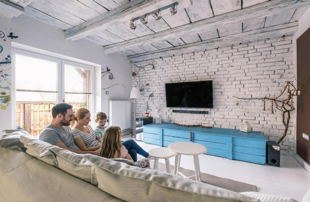 a family sitting on a couch in a living room at Apartmán Malý princ in Dolní Lomná