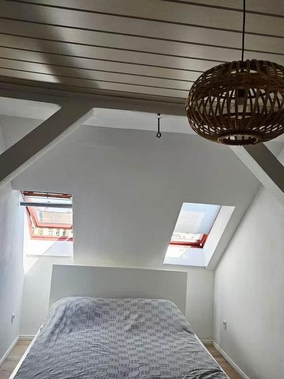 a bedroom with a bed and two windows at Dachgeschosswohnung in historischem Monument in Görlitz