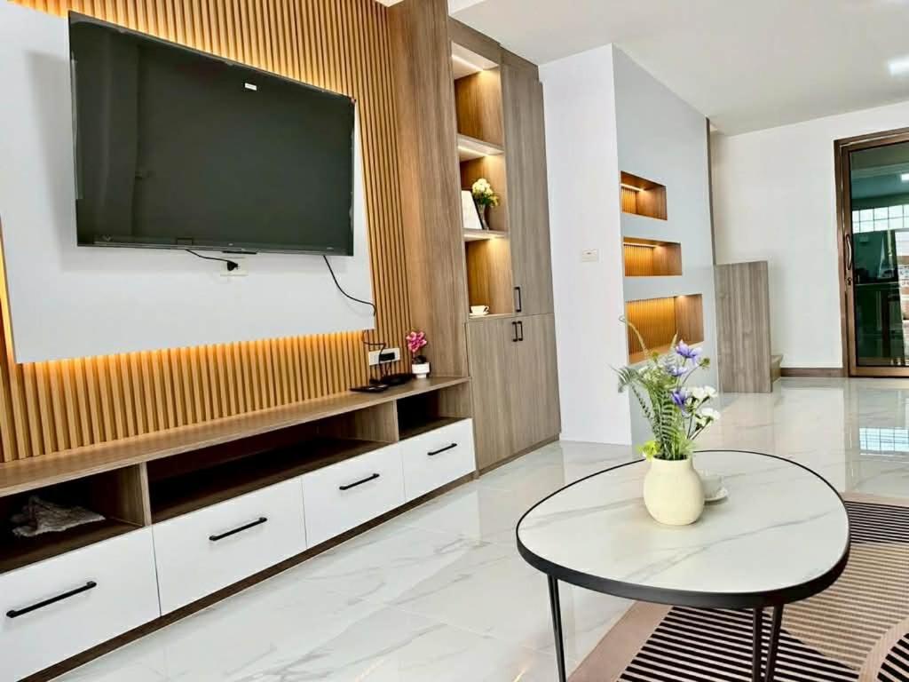 a living room with a large television on a wall at Apples Pattaya Townhouse in Pattaya South
