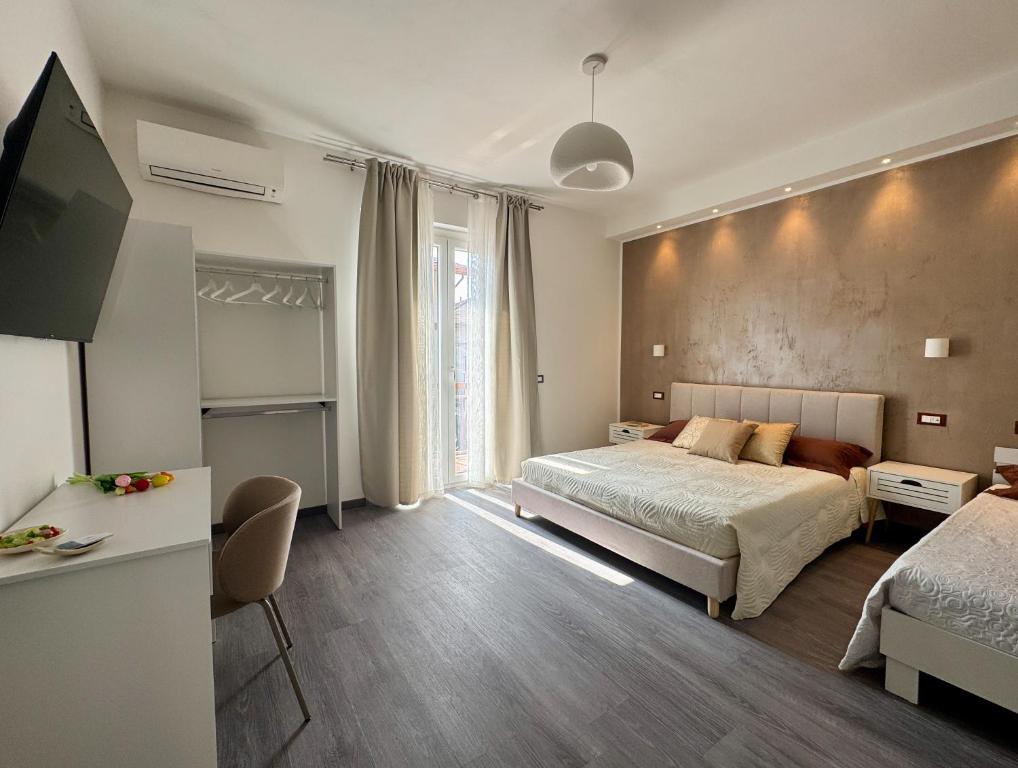 a bedroom with a bed and a desk and a television at Perla di Mare in Martinsicuro