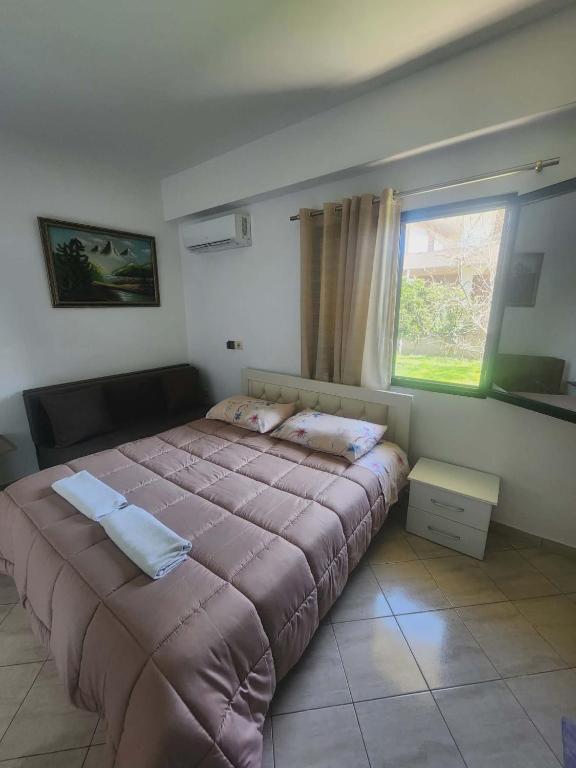 a large bed in a bedroom with a window at Apartment 2 by Villa Ceni in Elbasan