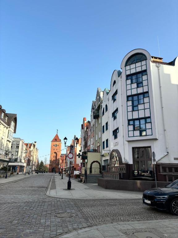 a cobblestone street in a city with buildings at Pokoje Stary Rynek in Elblag