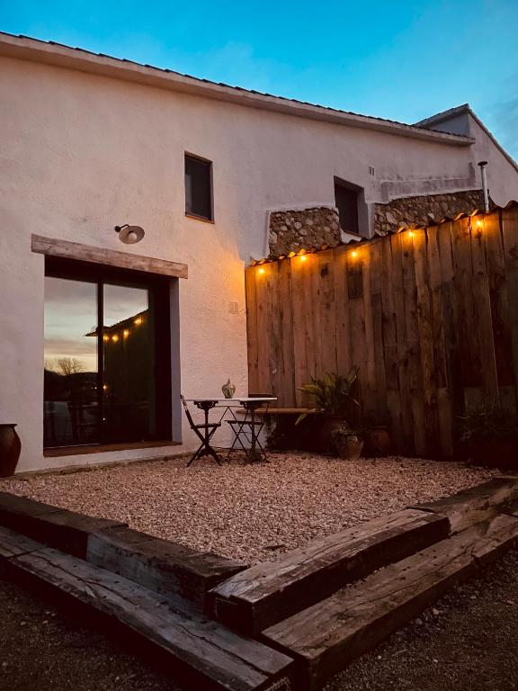a house with a wooden fence and a picnic table at Alojamiento Rural Montseny in Breda