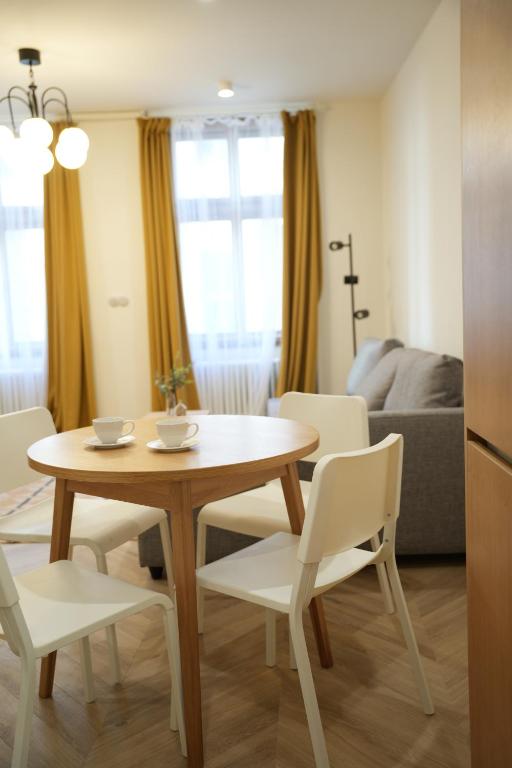 a living room with a table and chairs and a couch at Rezidence Jakubská in Brno