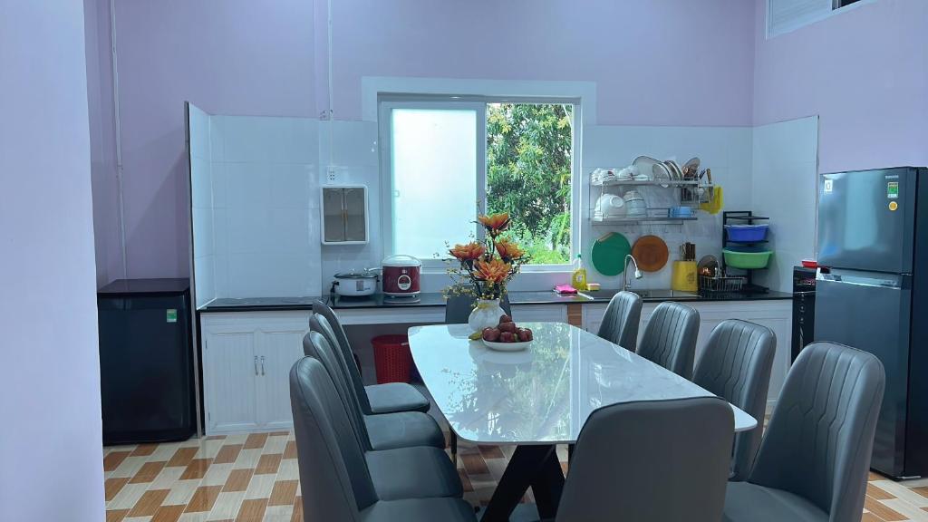 a kitchen with a table and chairs and a table and a window at Ryo Homestay Dốc Lể in Ba Ha