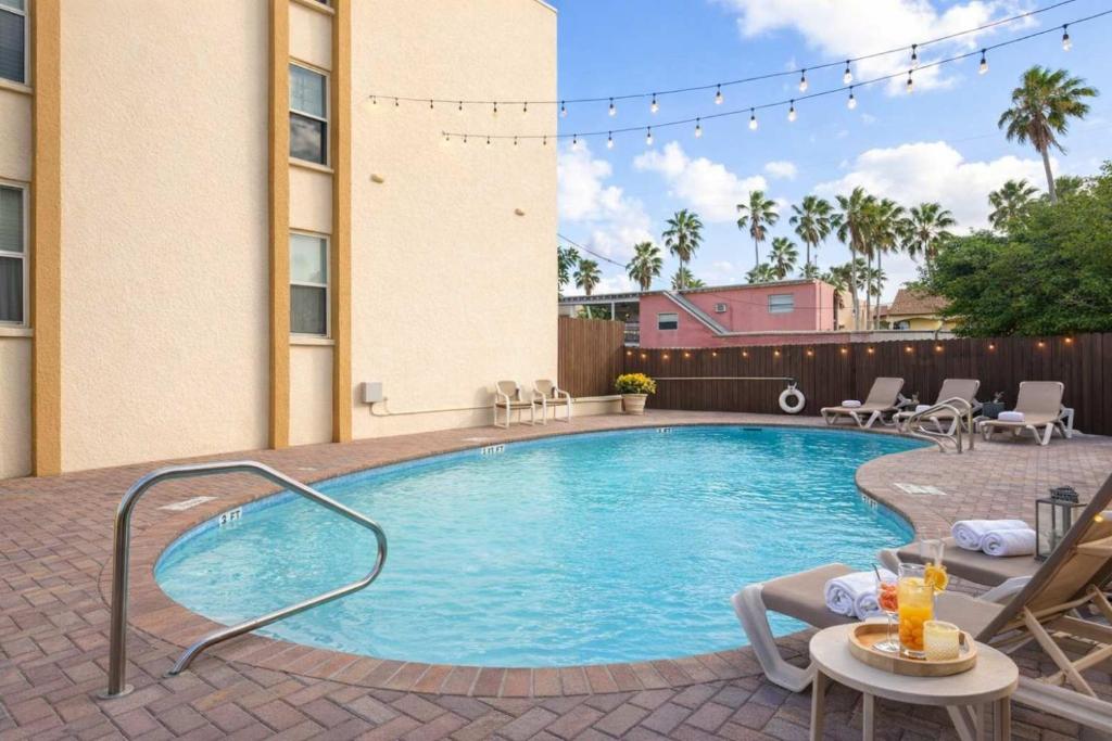 a large swimming pool with chairs and a table at Fiesta Sol #110 home in South Padre Island