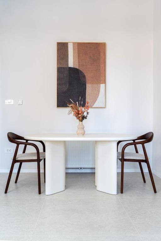 a white table with two chairs and a vase with flowers at Palmotić Heritage Suites - Main Square - FREE Parking in Zagreb
