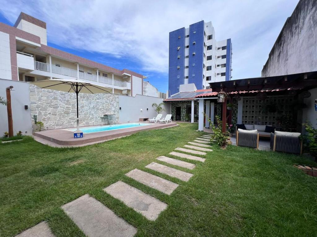 a backyard of a building with a swimming pool at Recanto dos Maias in Aracaju