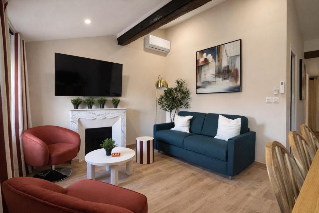 a living room with a blue couch and a fireplace at New - Appartement ou Studio Centre Ville Confort in Grasse