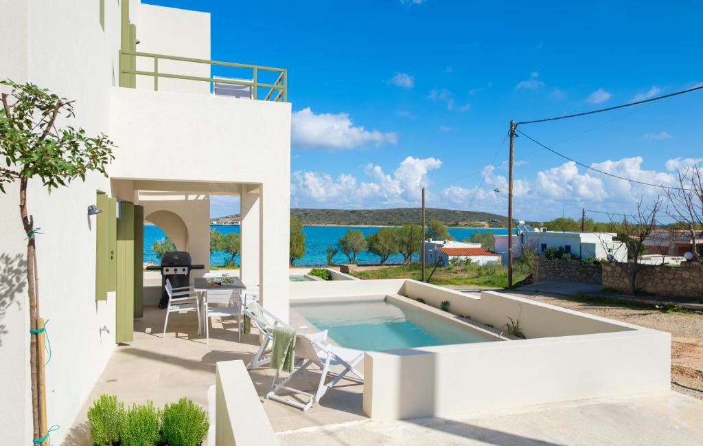 a white house with a swimming pool and a patio at Villa Selina 4 - Etheras Properties in Kythira