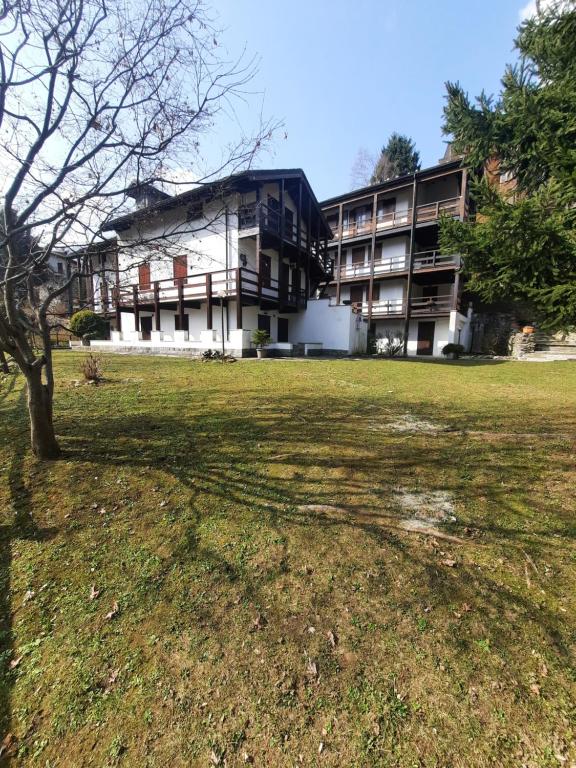 a building with a tree in front of a field at casa RIVER in Scopello