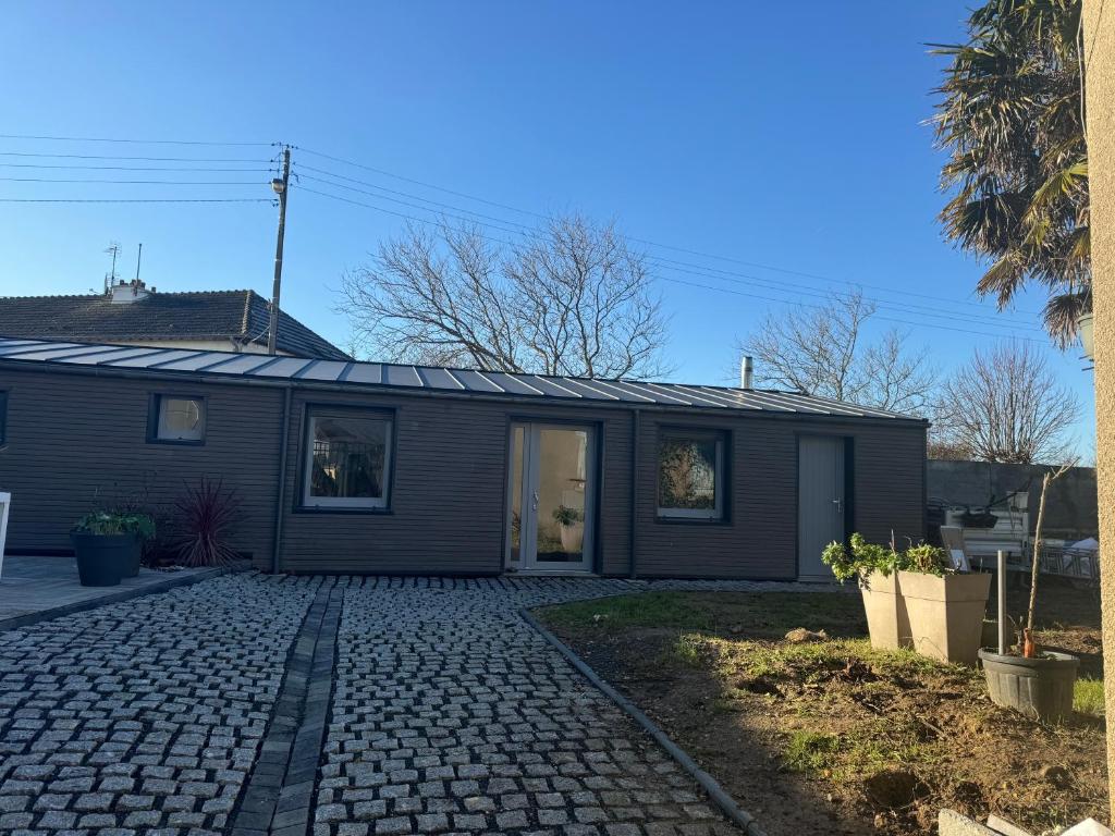 a house with a brick driveway in front of it at Suite 150 m de la mer in Luc-sur-Mer