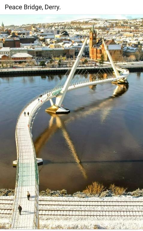 a bridge over a river with a city in the background at Derry City Centre Kelly's Place et in Derry Londonderry