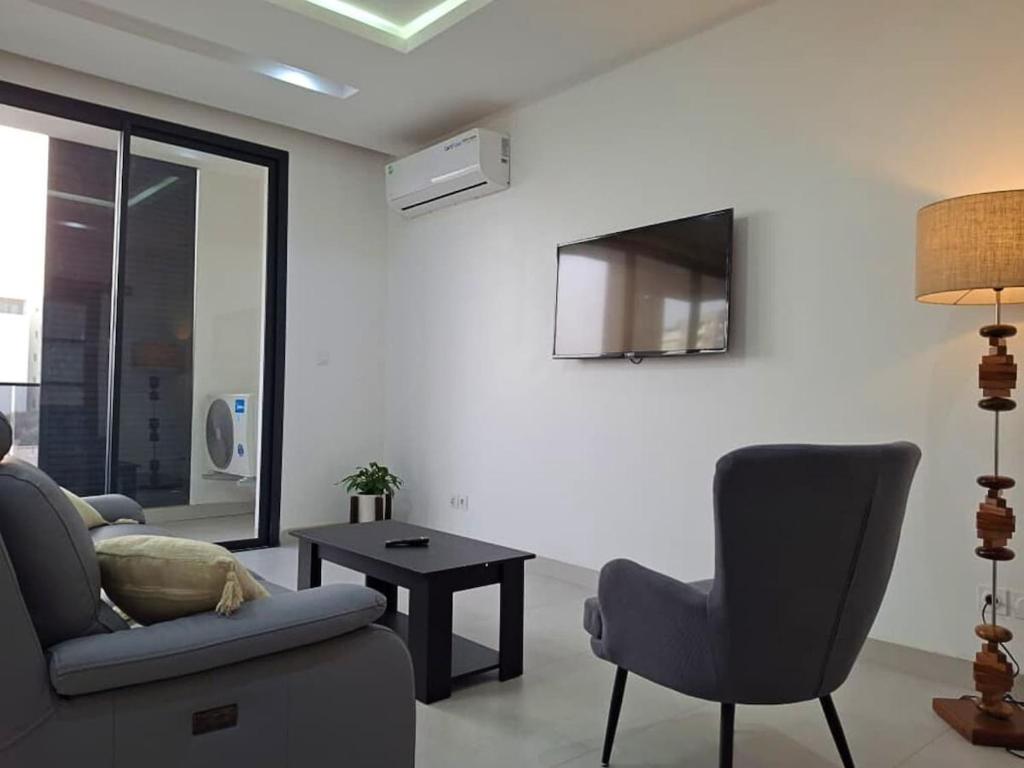 a living room with a couch and a chair and a table at Elegant 3-room apartment in Dakar