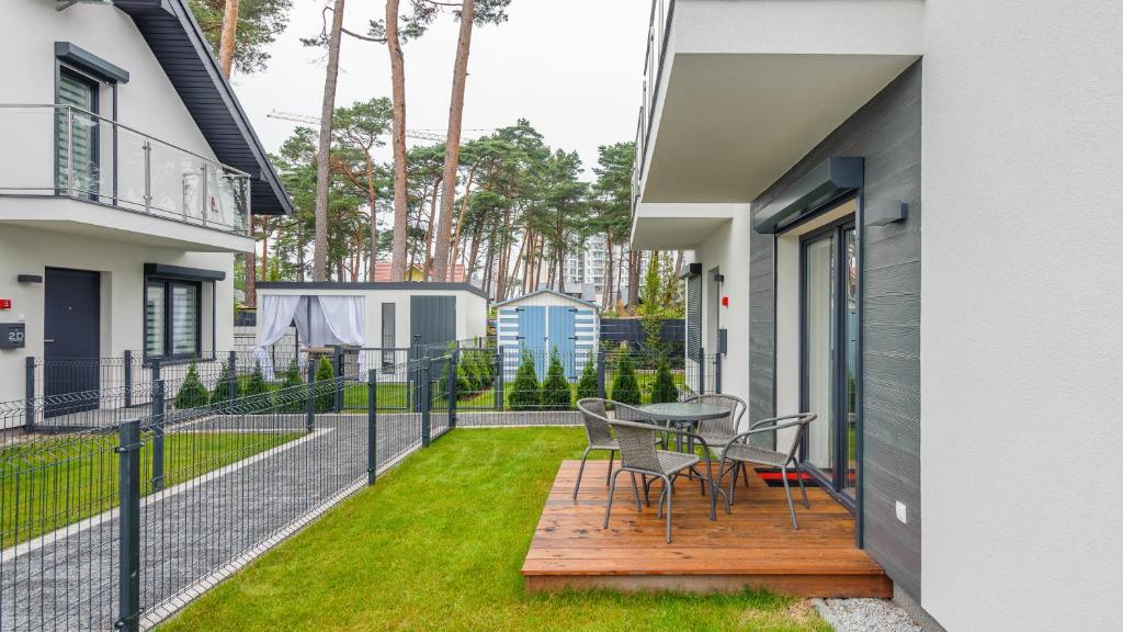 a balcony of a house with a table and chairs at Dom Horizon Park 3A in Dziwnówek