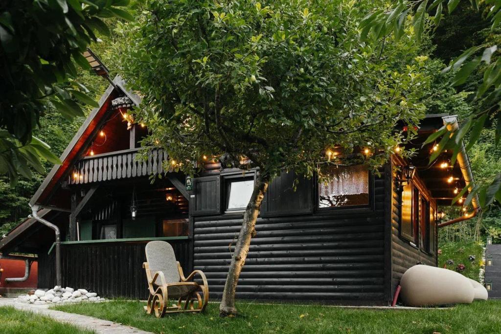 a house with a tree and two chairs in front of it at Hishka Ishka Love in Iška