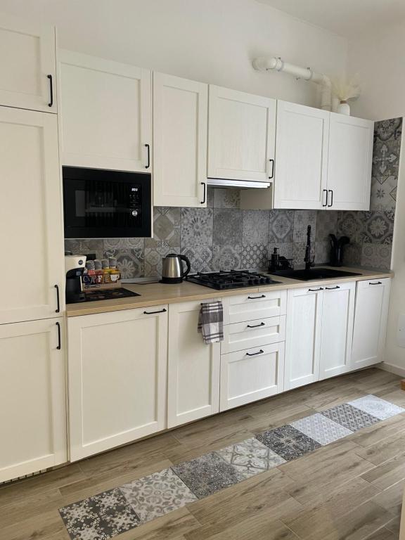 a white kitchen with white cabinets and a stove at Casa Rebocco in La Spezia