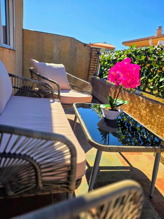 a patio with chairs and a table with a flower on it at Casa del sol Armilla in Armilla