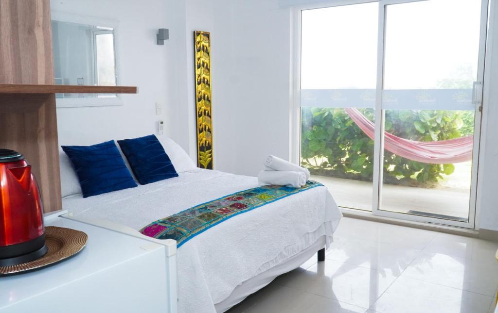 a white bedroom with a bed and a large window at Sunshine Boutique Hotel in San Andrés