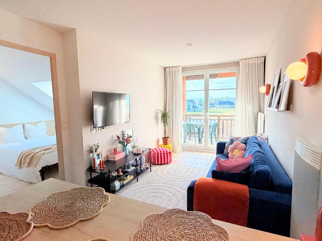 a living room with a bed and a blue couch at Au cœur des vignes - Piscine Sauna & Climatisation in Levernois