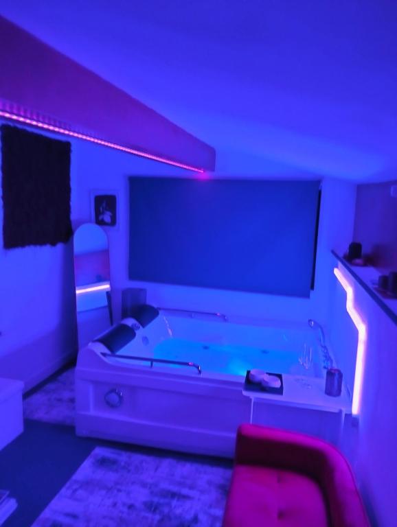 a living room with a large tv and purple lights at Tudesia royal suite in Todi