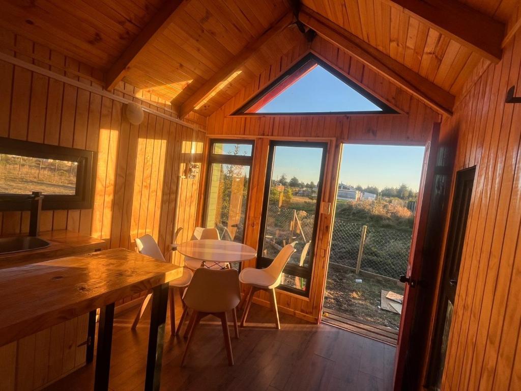 ein Zimmer mit Tisch und Stühlen und einem Fenster in der Unterkunft tiny house DyL in Puerto Montt
