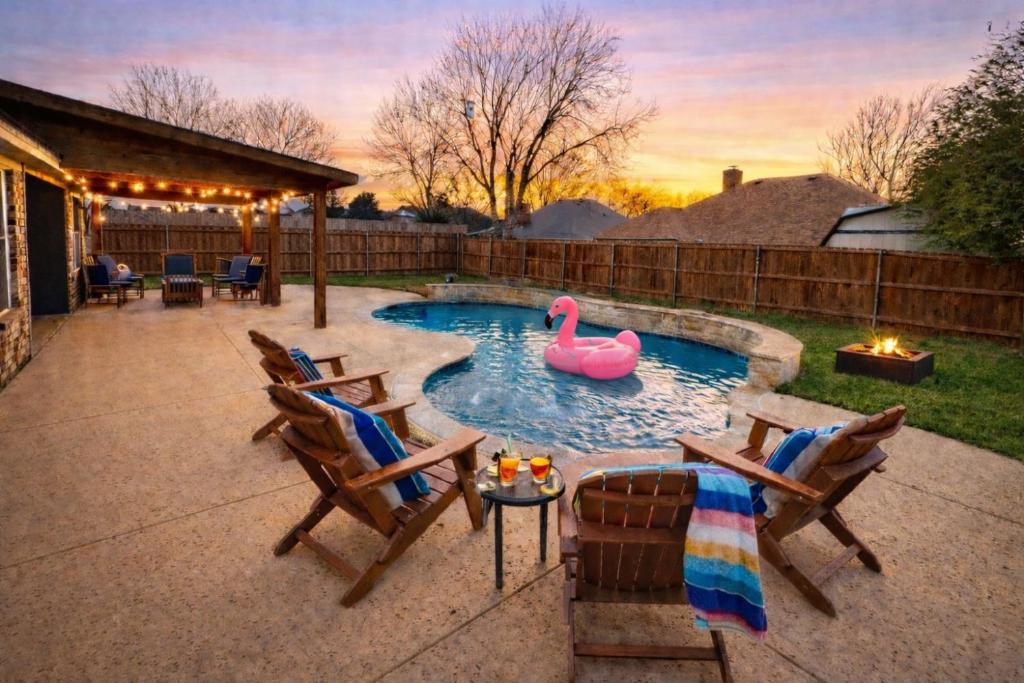 a swimming pool with a pink swan in a backyard at Keller Charm-Near Bear Creek Park & Stadiums,Pool in Keller