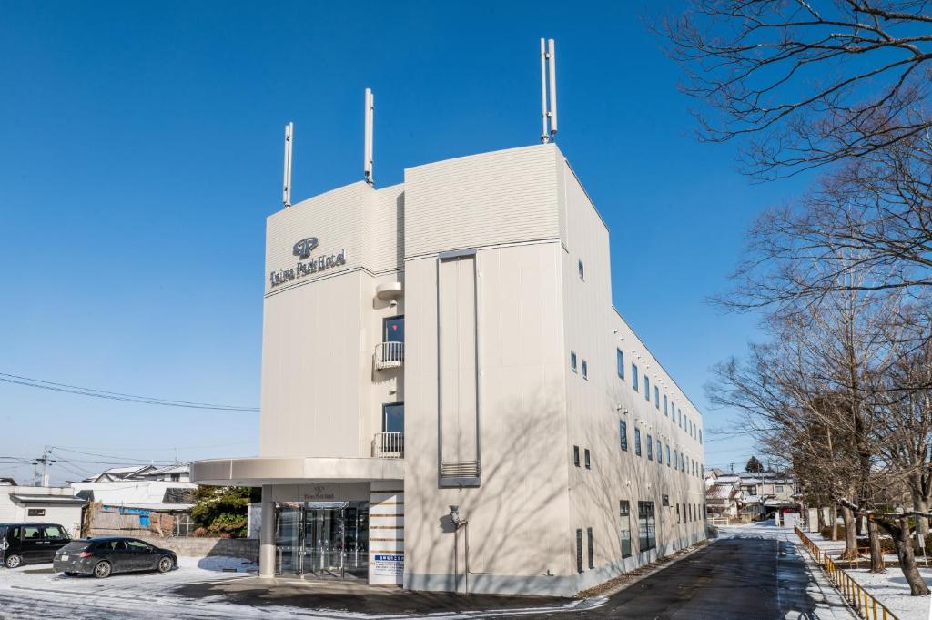 a white building with a sign on it at 大和パークホテル in Taiwa