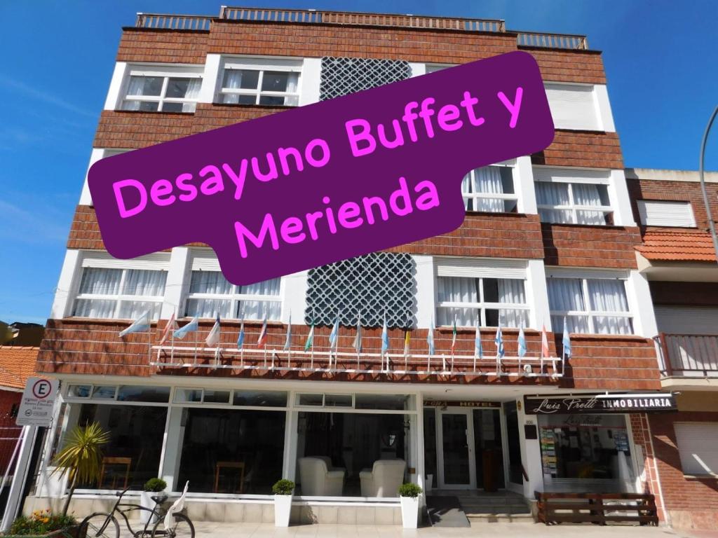 a building with a purple sign in front of it at Lugra Hotel in Miramar