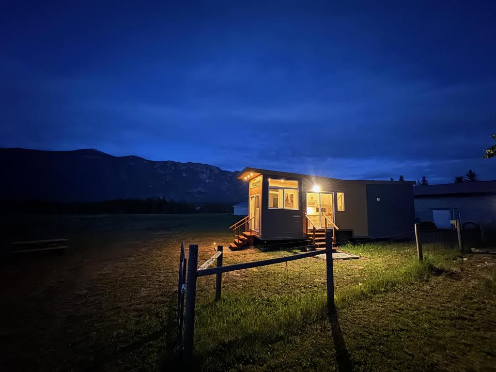 a tiny house sitting in a field at night at Mountain View Retreat in Creston