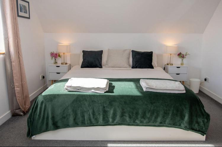 a bedroom with a large bed with a green blanket at Inskeyft - Kirkwall in Kirkwall