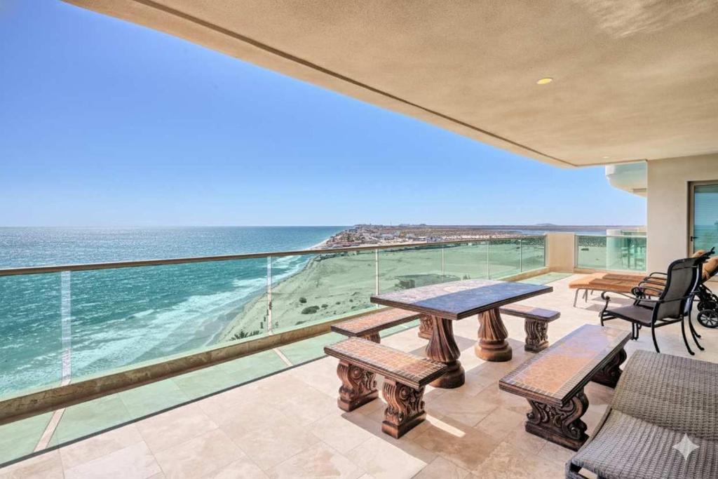 a balcony with a table and chairs and the ocean at Ocean Wrap Around Oceanfront Balcony at Tessoro in Las Conchas