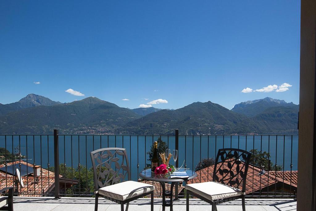 a table and chairs on a balcony with mountains at Le Petit Palais Villa in Plesio