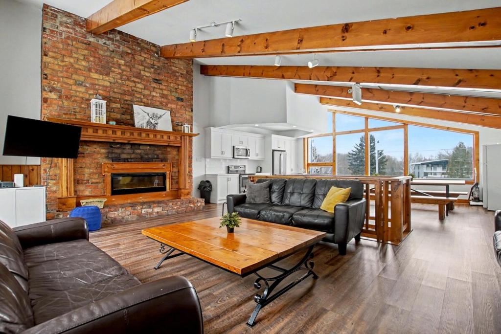 a living room with a couch and a table at Birch View- Balcony-Backyard-Parking-Sauna-Sleeps 20 in Blue Mountains