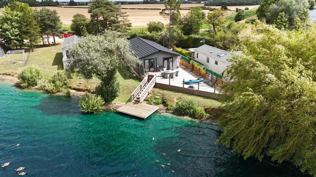 an aerial view of a house with a bridge over a river at 3 Bed in Tallington oc-s30309 in Yaxley