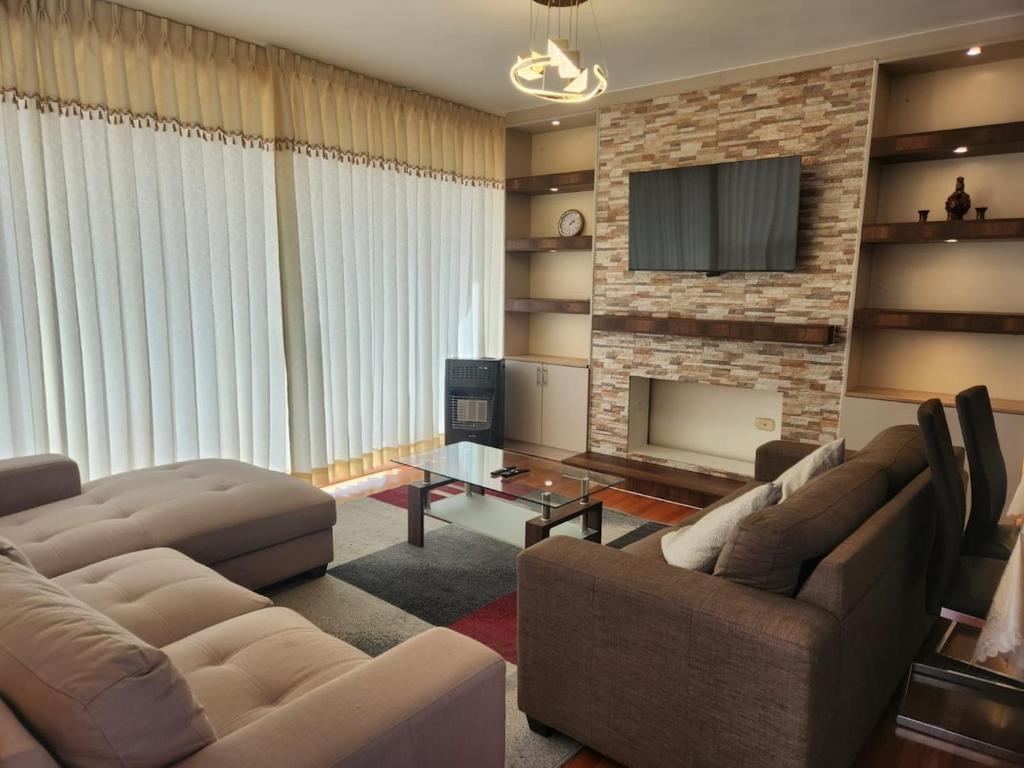 a living room with two couches and a fireplace at Refugio del Lago in Puno
