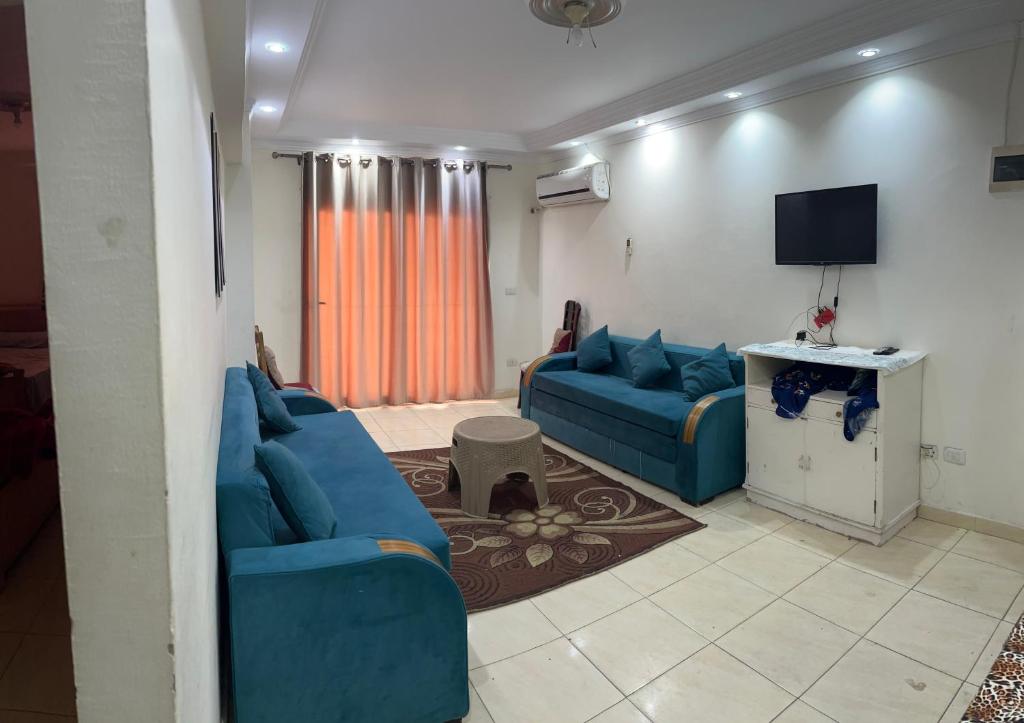 a living room with blue couches and a tv at Light Tower in Alexandria