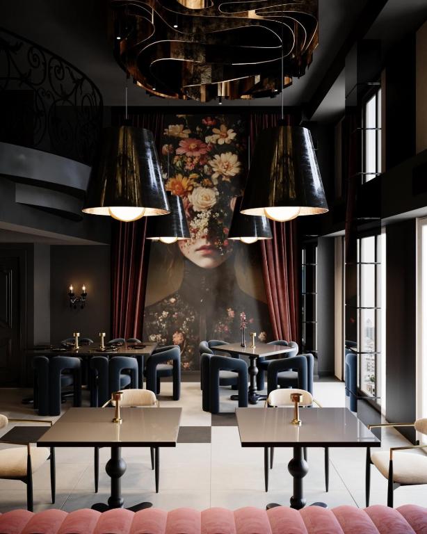 a restaurant with tables and chairs and a painting at Hotel Bela Kuka - White House in Bitola