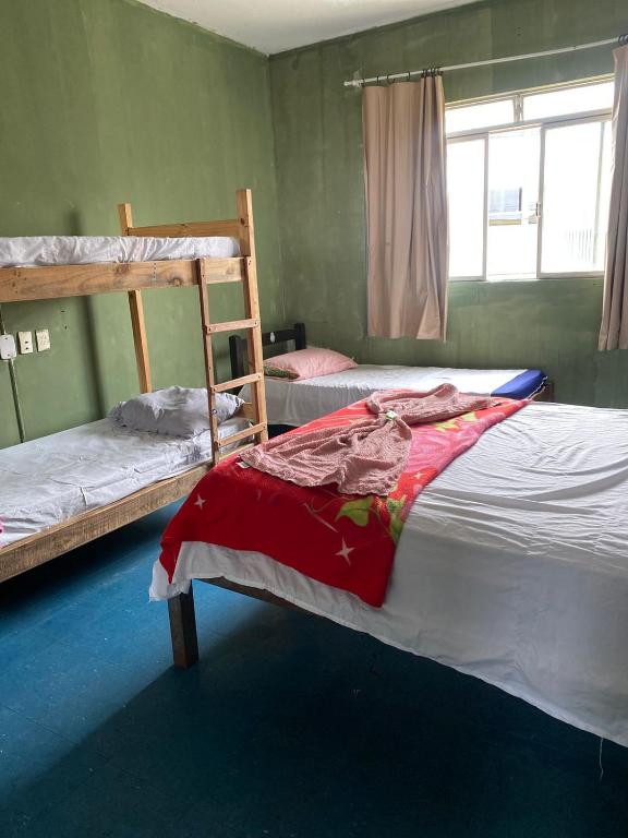 a bedroom with two bunk beds and a window at Quarto econômico central in Sete Lagoas