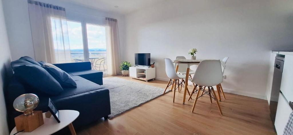 a living room with a blue couch and a table at Valença Sky View in Valença