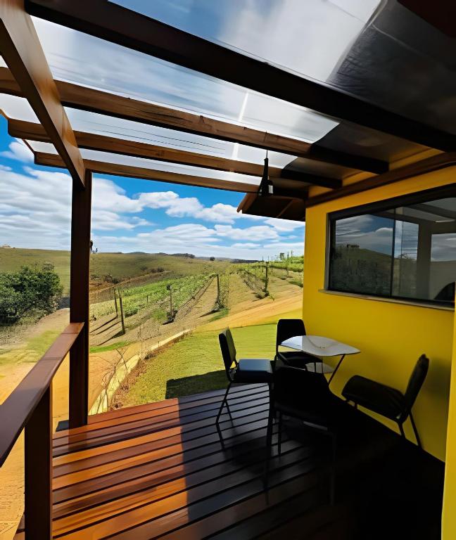 a view from the deck of a house with a table and chairs at Vinhedo Villarejo - Chalés do Vinhedo in Paty do Alferes